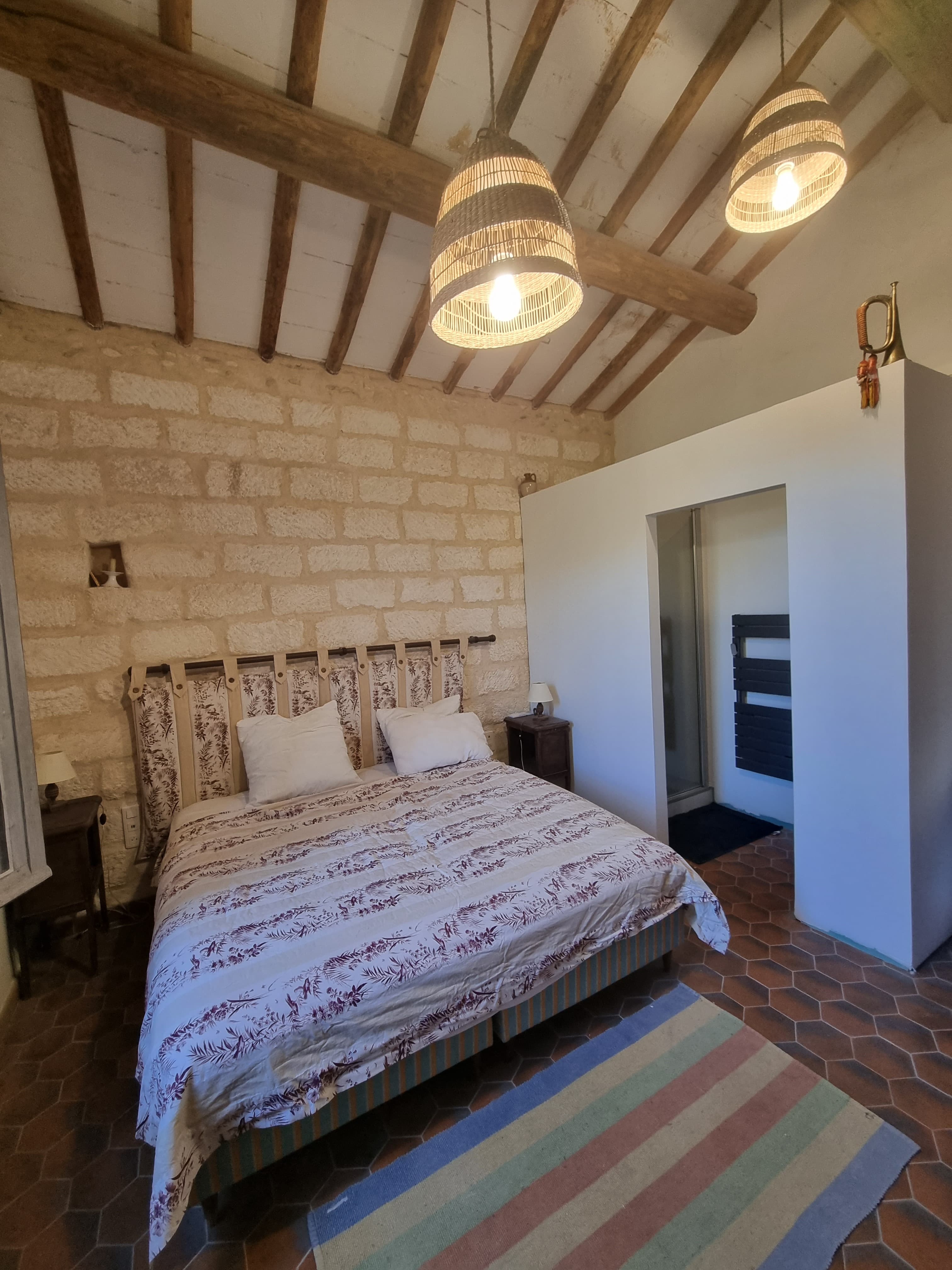 The Flamingo Room — king-size bed, full exposed stone feature wall and rattan pendants