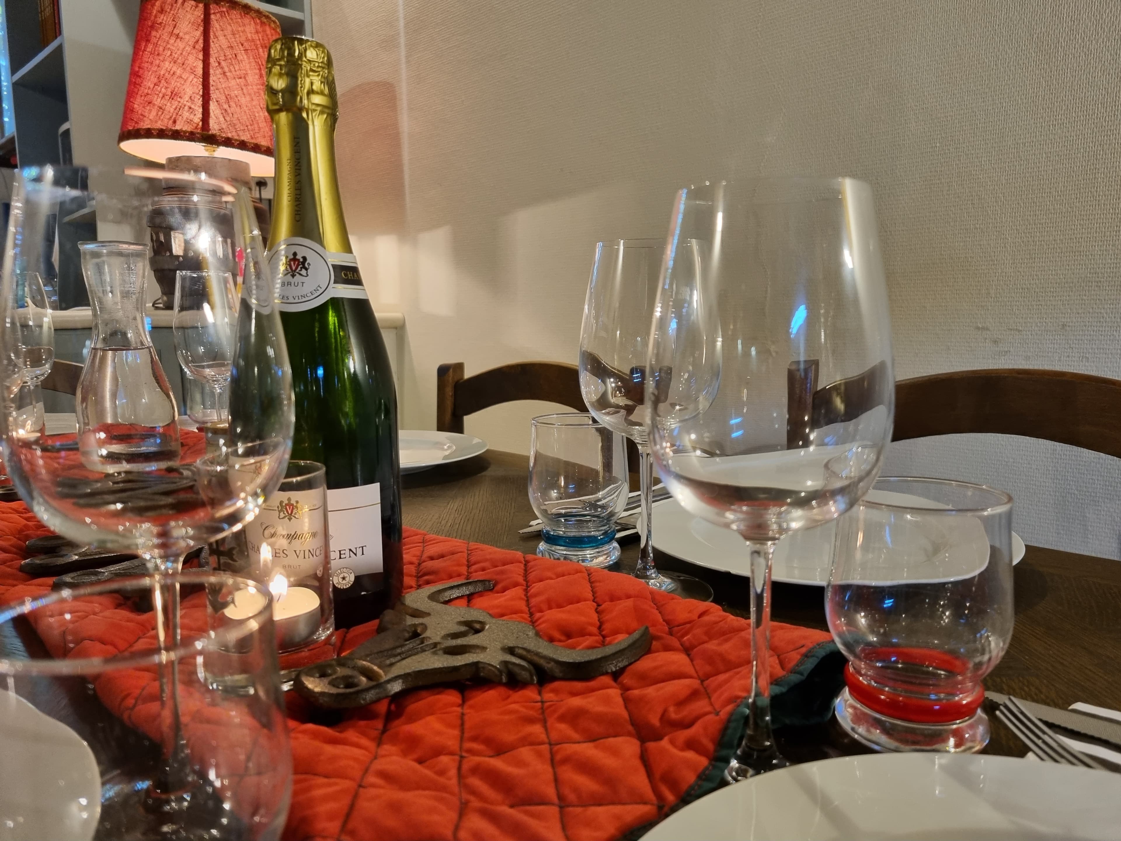 Dining table set for an evening meal with champagne and glassware