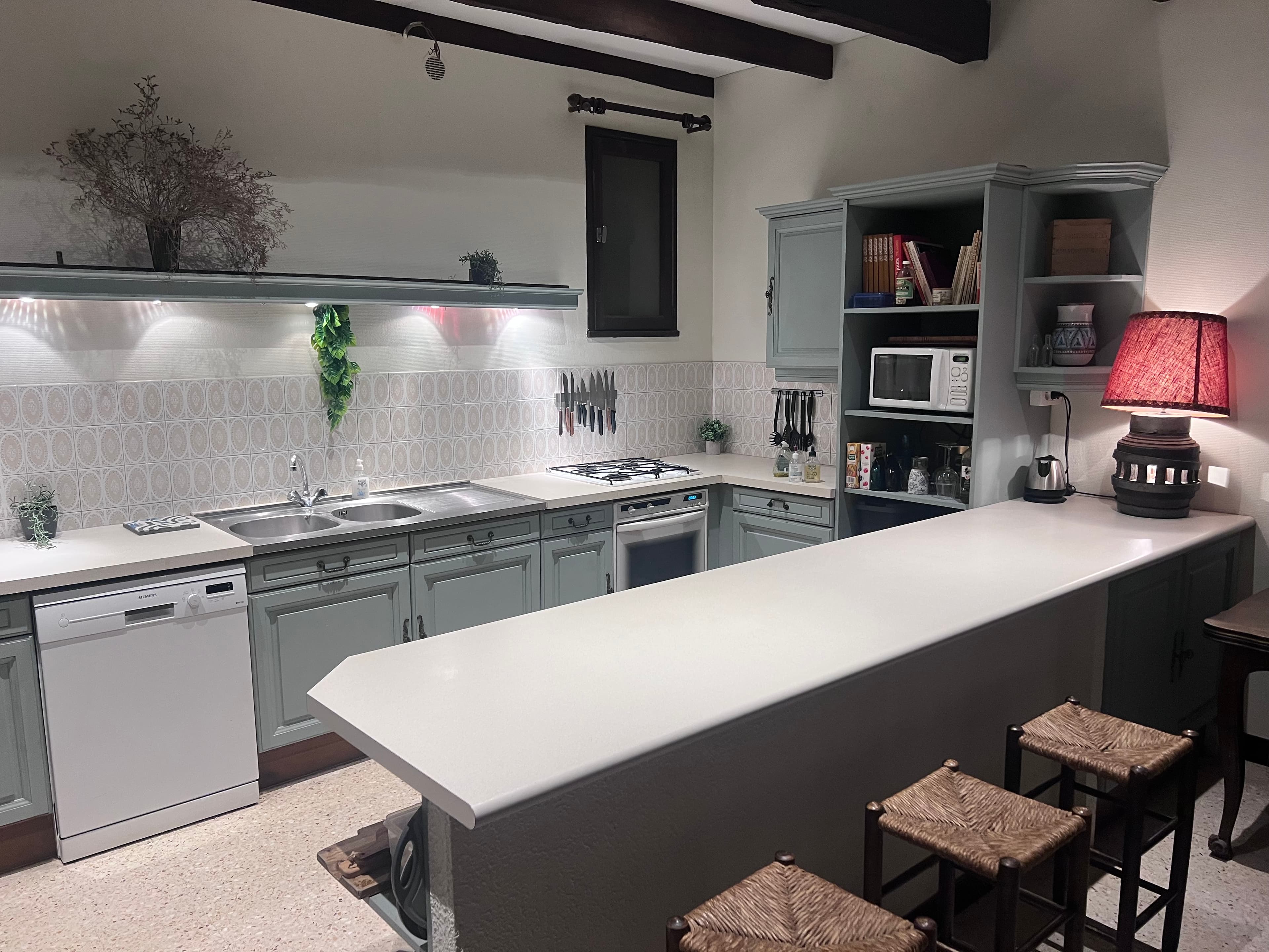 Fully equipped kitchen with breakfast bar and sage-green cabinetry