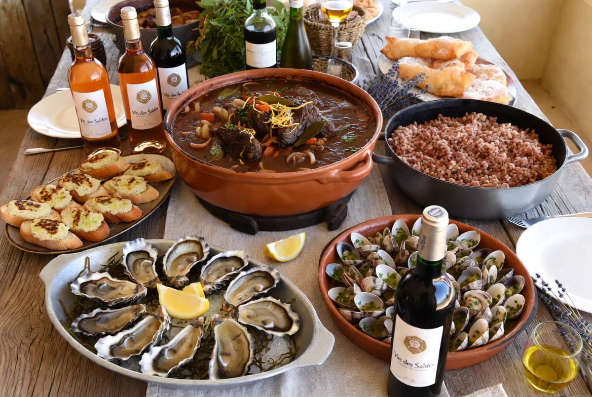 A display of regional produce including gardianne, wild rice, tellines, and oysters.